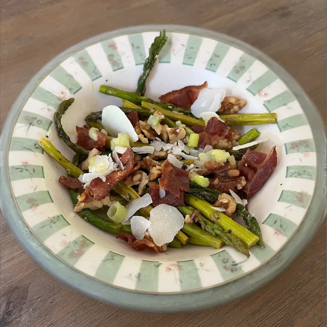Plated asparagus, bacon and walnut salad with shaved parmesan and a lemon honey dressing.