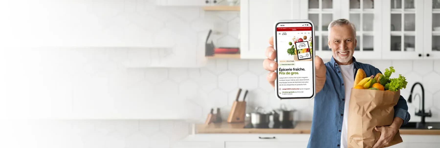 A smiling customer in his kitchen shows the Marché CTFO site on his phone, holding a bag of groceries