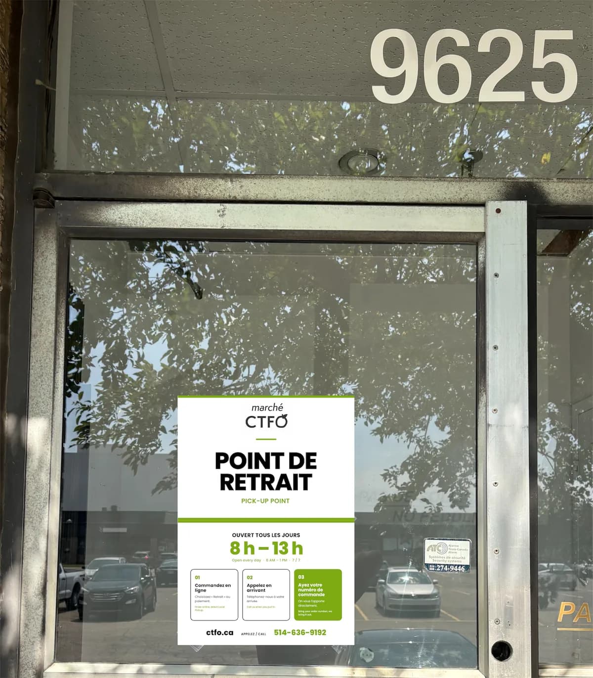 Close-up of the entrance door showing the green Marché CTFO Pick-Up Point poster with 8 AM to 1 PM hours.